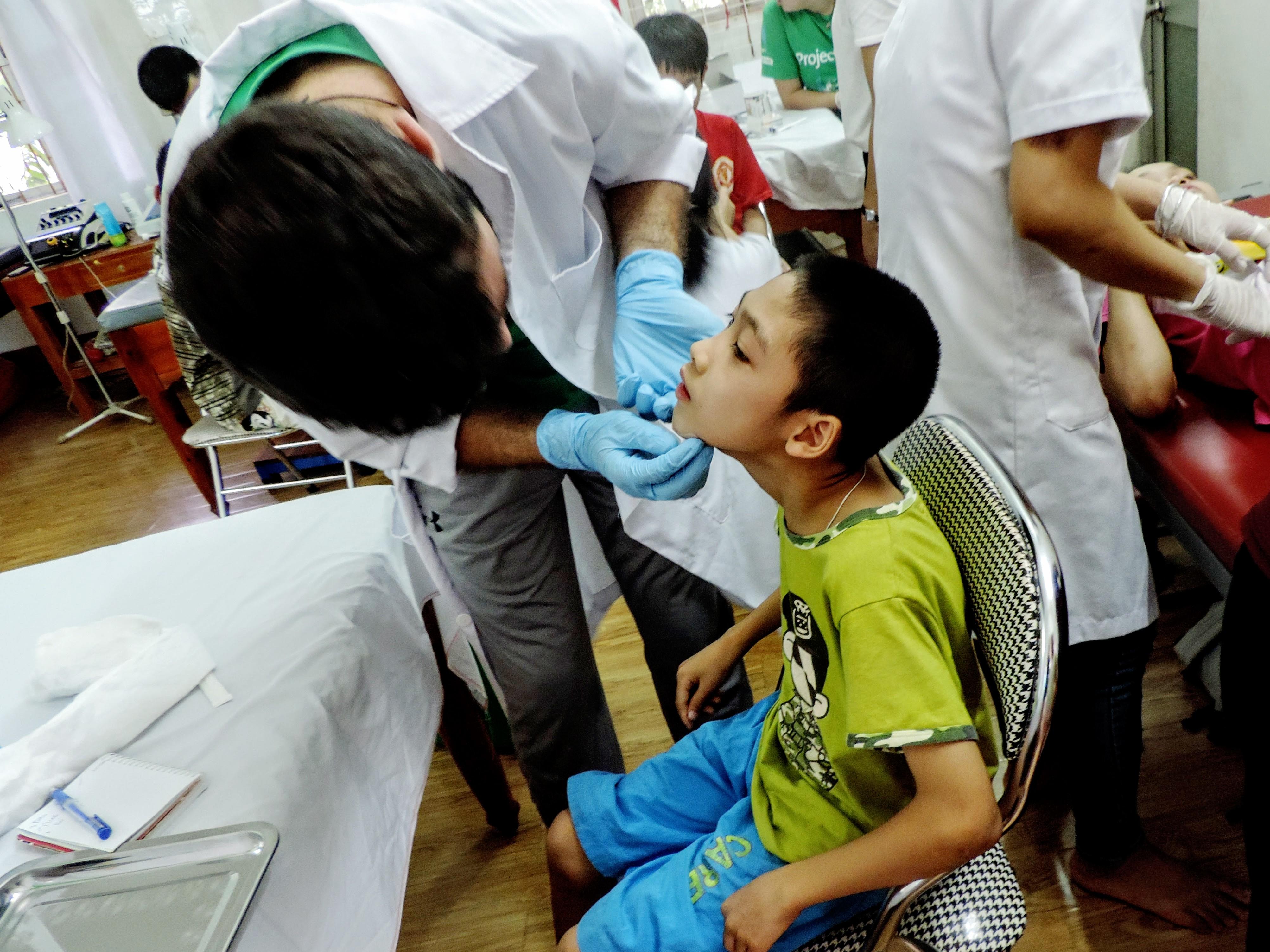 Un interno realizando un chequeo médico a un pequeño paciente durante sus prácticas de Enfermería en Vietnam. Interno de Enfermería en Vietnam realiza un chequeo básico.